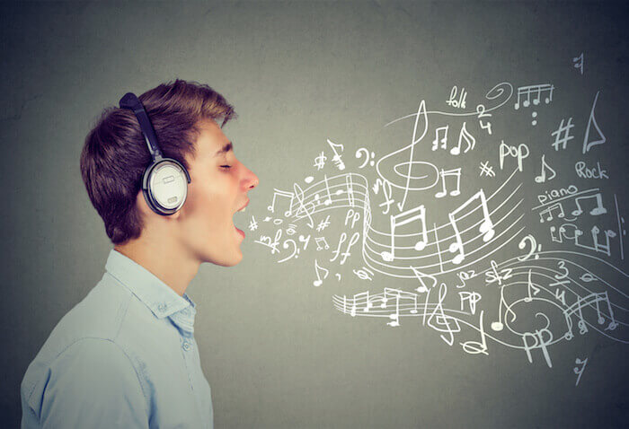 Young man singing with music notes coming out of mouth