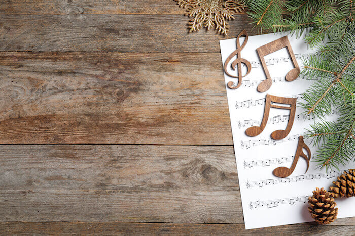 Composition with music sheet and notes on wooden background. Christmas songs concept